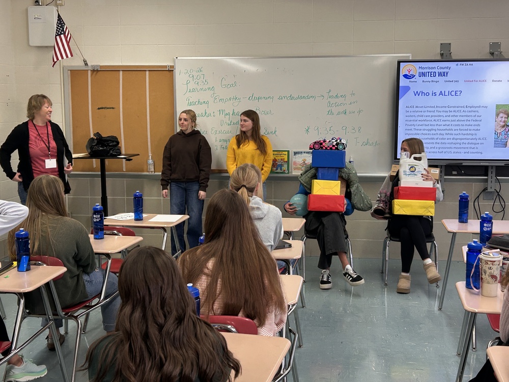 student in front of class with packages on their laps