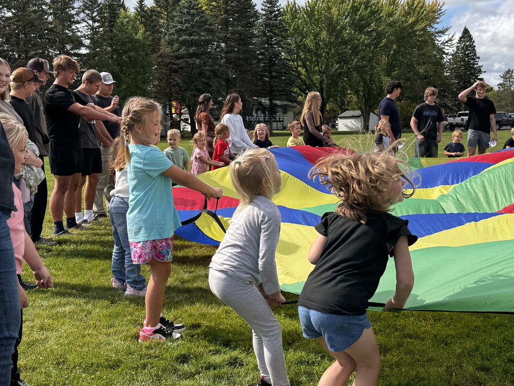 kids playing with parachute outside