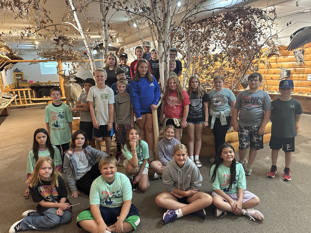 students in museum looking at camera posed