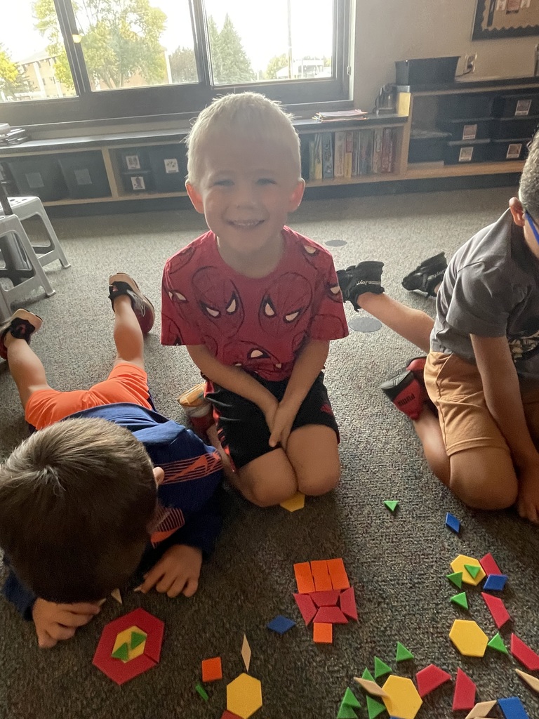 boy with red shirt and short hair making shapes