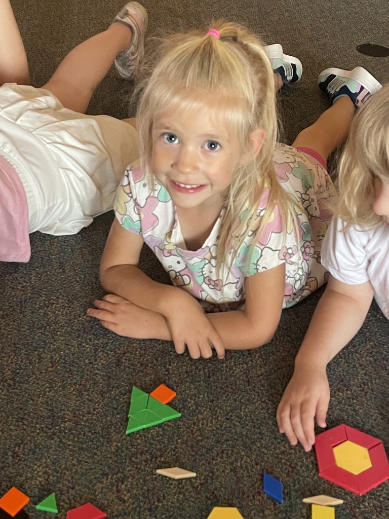 girl with blonde hair making a christmas tree shape