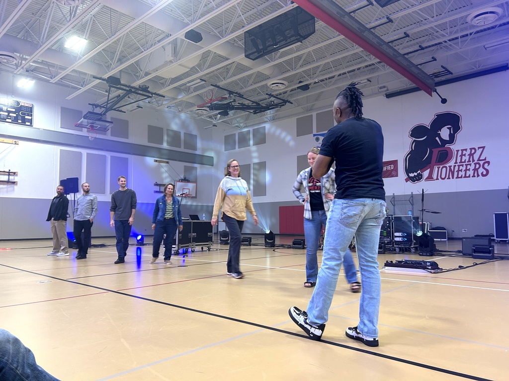 teachers standing in front of students in Pioneer gym