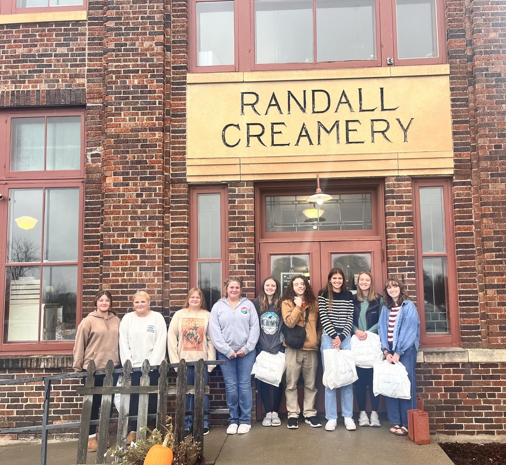 students looking at camera standing in front of randall creamery brick building