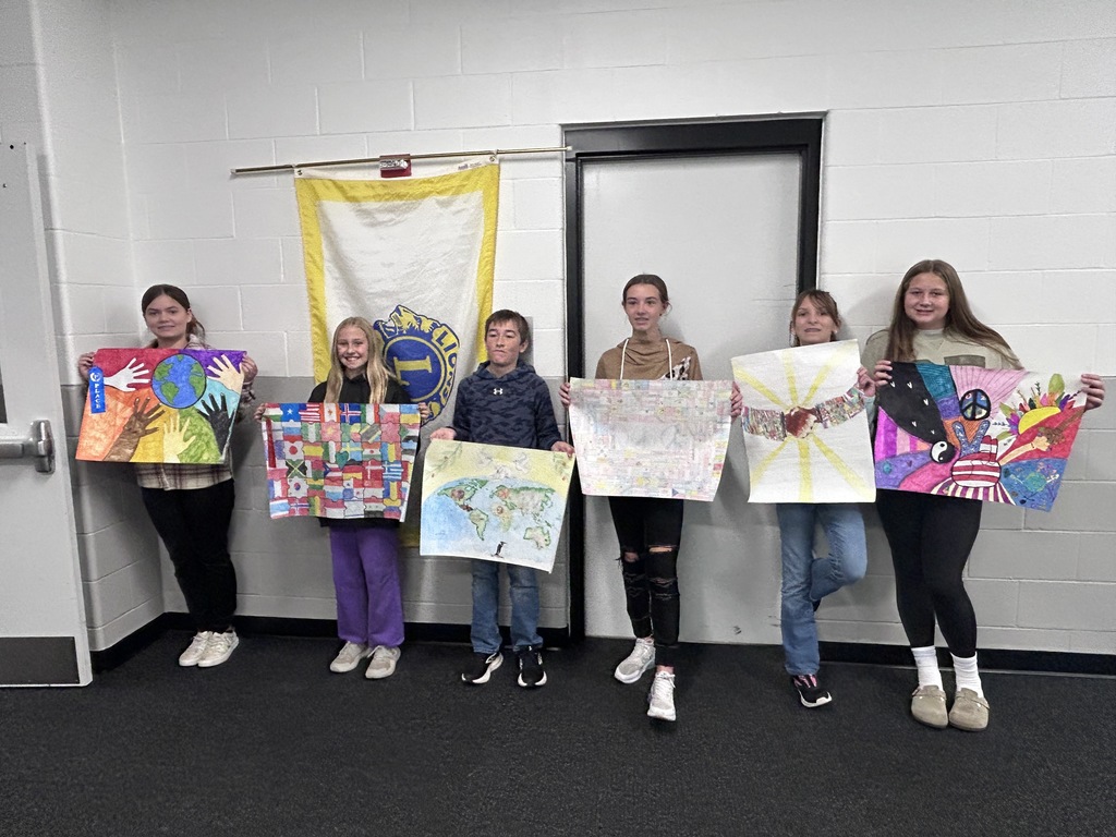 six students holding their peace posters smiling at the camera