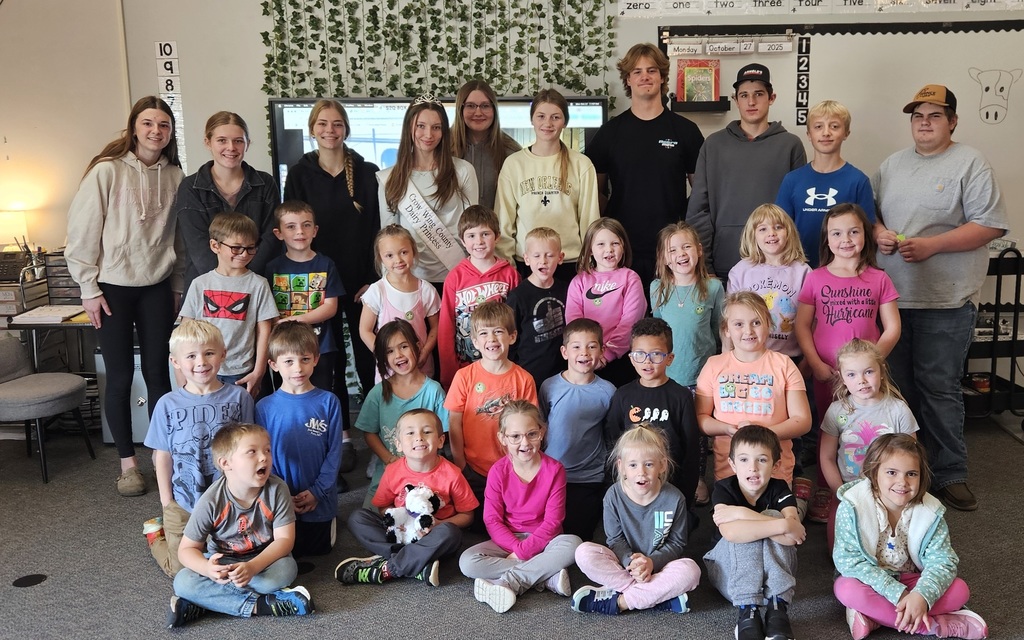 gorup of High schoolers and kindergartners looking at the camera smiling