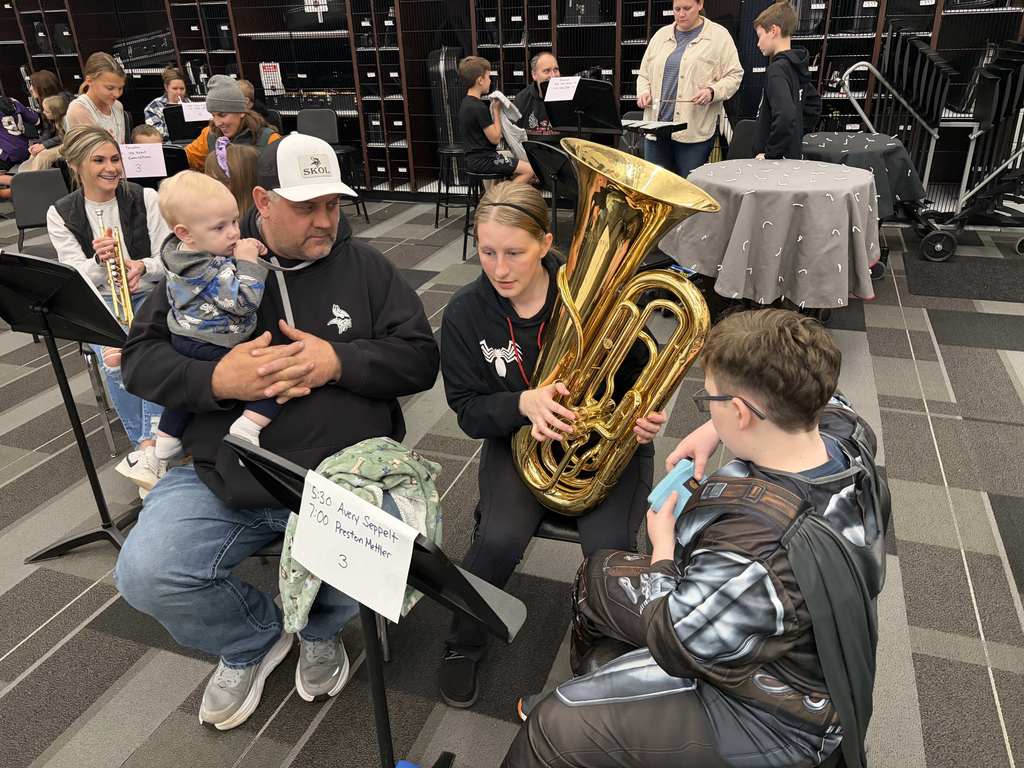 Band students with parents looking at camera playing instruments