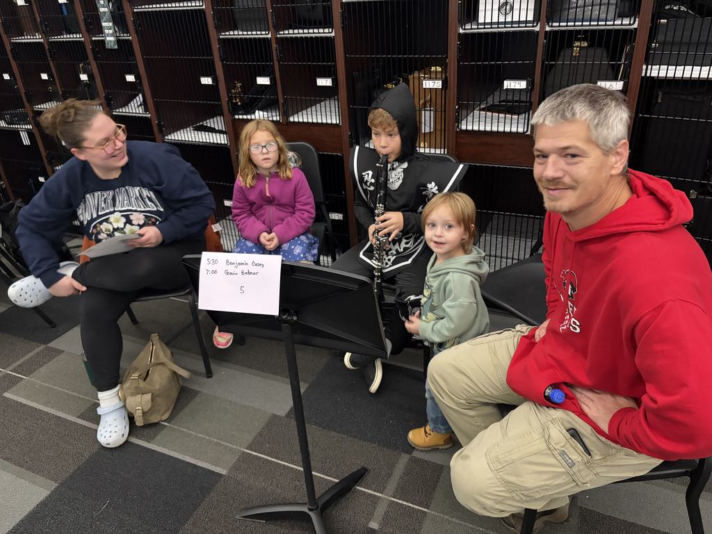 Band students with parents looking at camera playing instruments