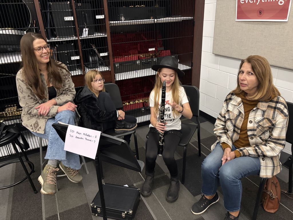 Band students with parents looking at camera playing instruments