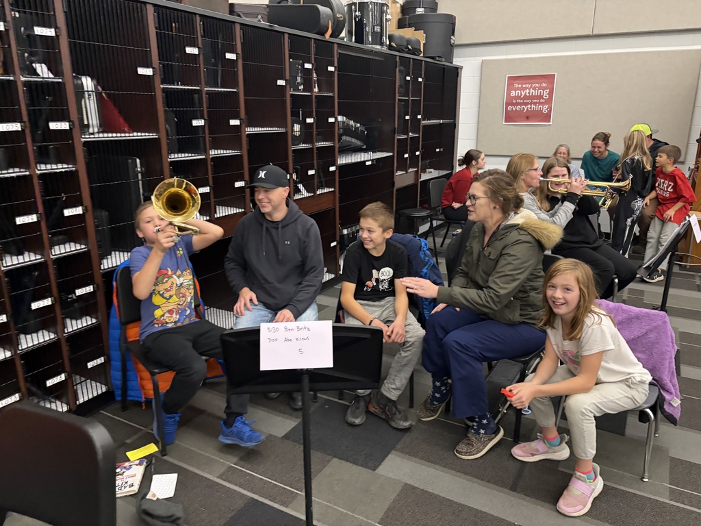 Band students with parents looking at camera playing instruments