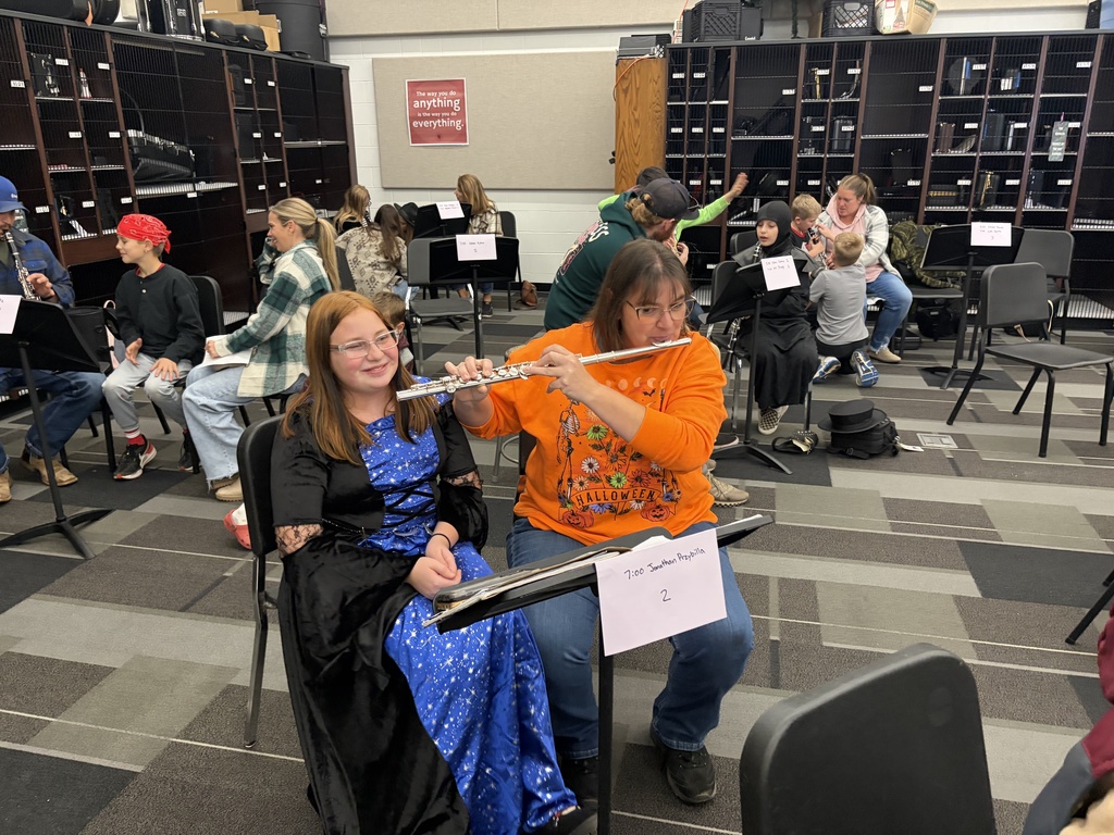 Band students with parents looking at camera playing instruments