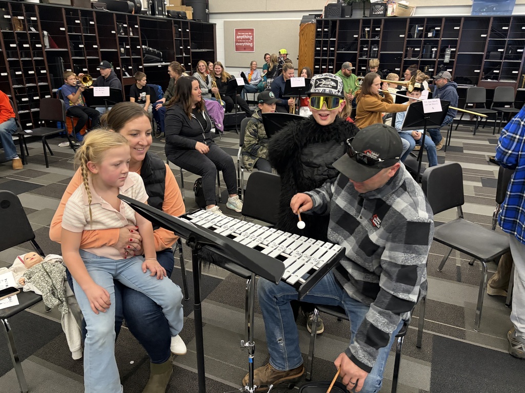 Band students with parents looking at camera playing instruments