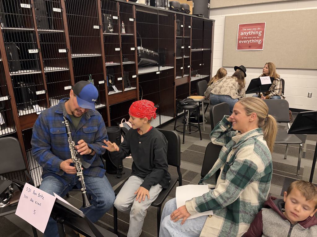 Band students with parents looking at camera playing instruments