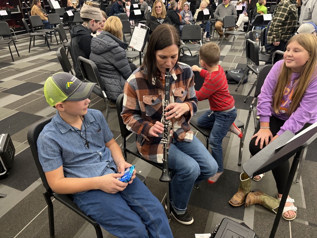 Band students with parents looking at camera playing instruments