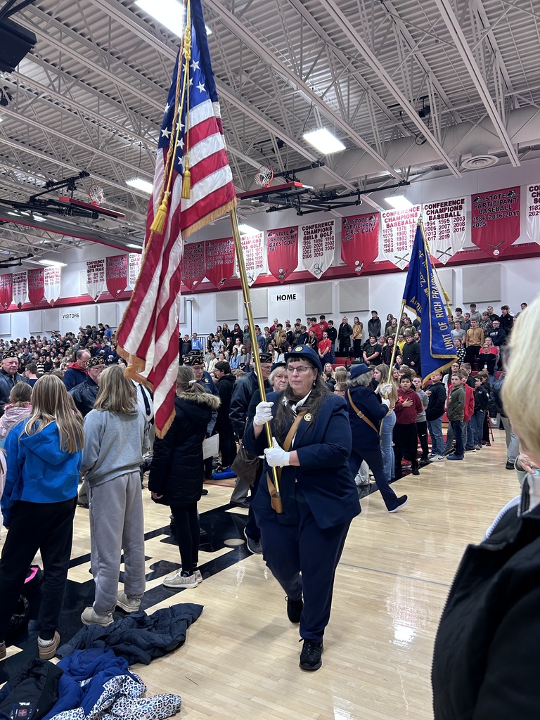 American Legion woman carrying flag in the MAC gym