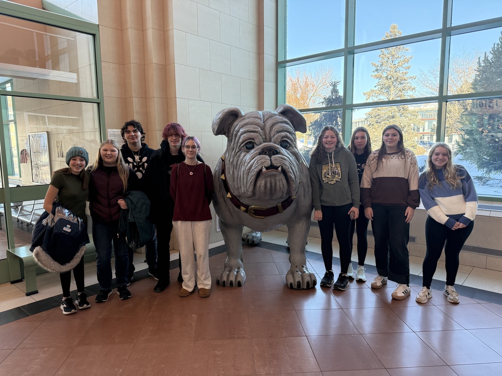 students standing with UMD mascot a large bulldog