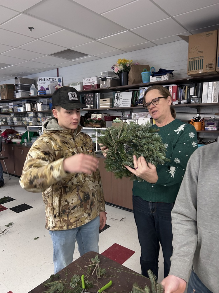 student and teacher with wreath 