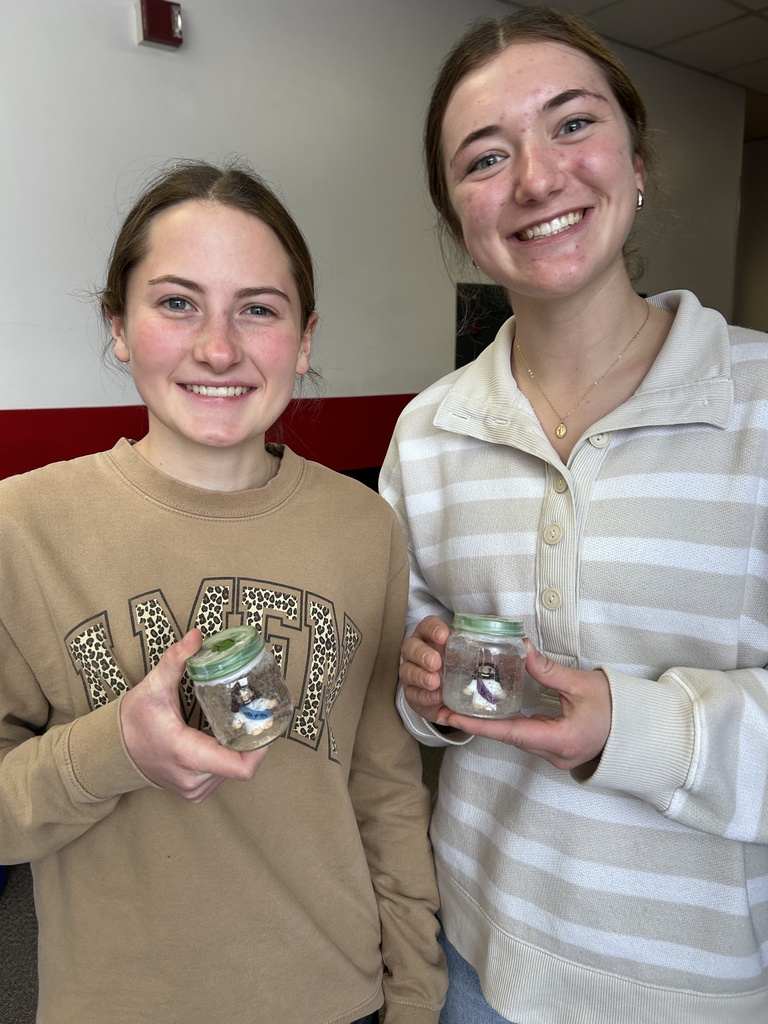 Students holding finished snow globe porjects