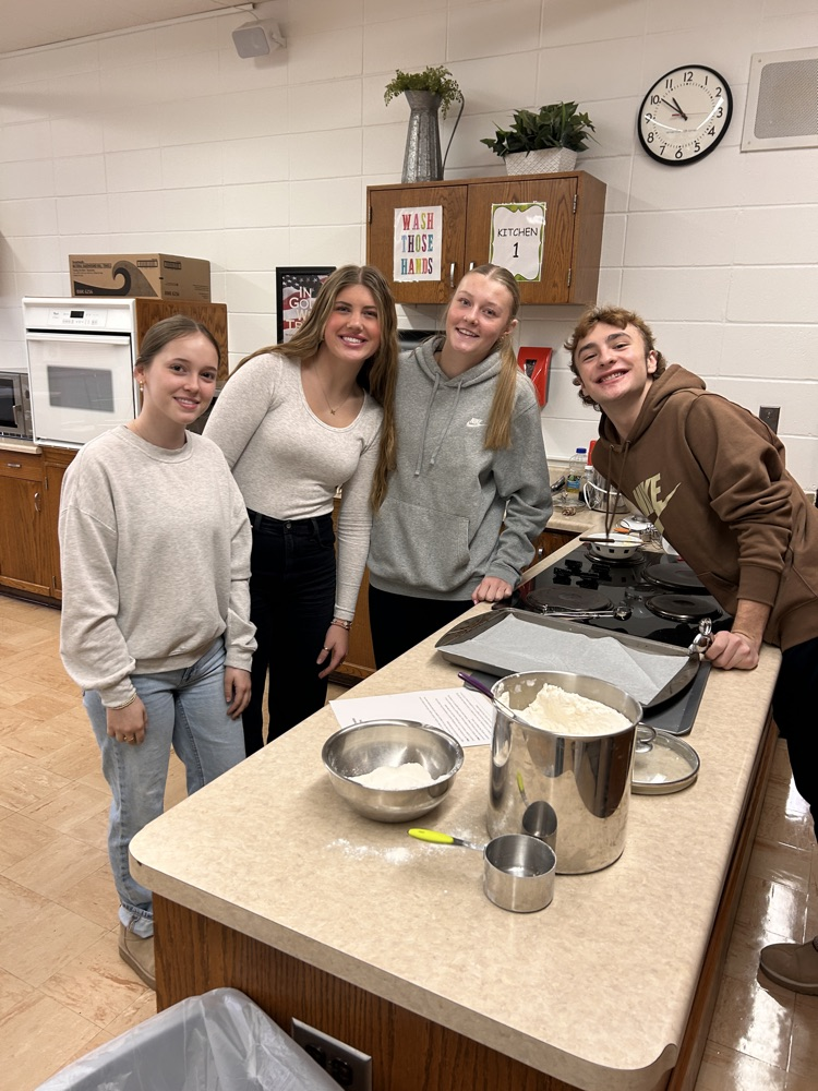 students in kitchen looking at camera