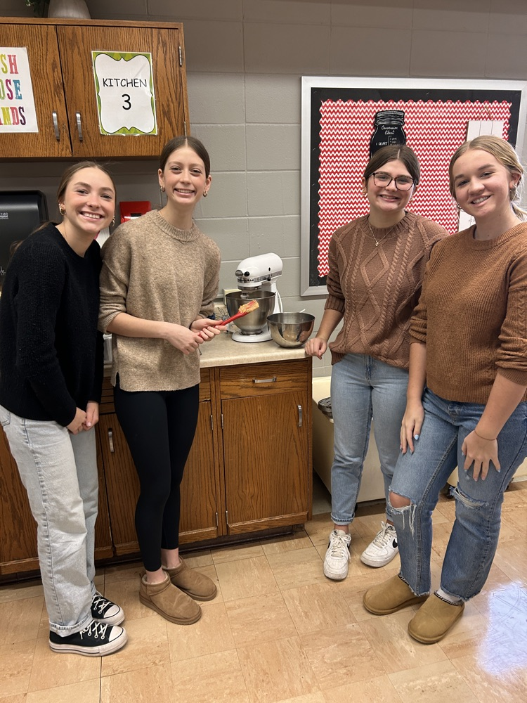 students in kitchen looking at camera