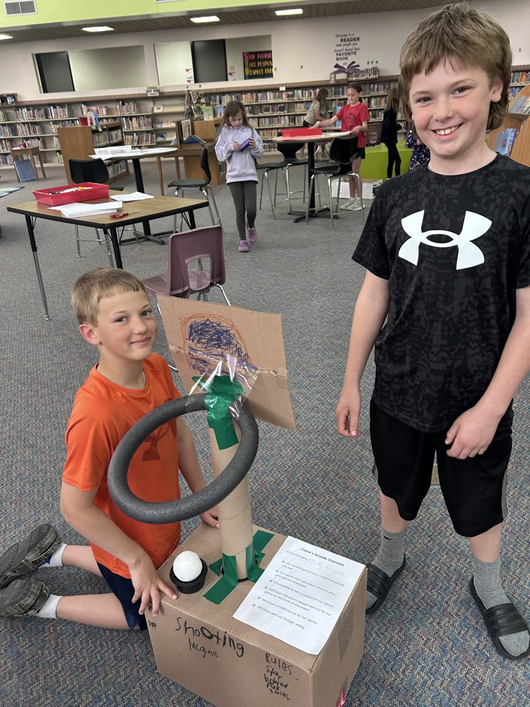 cardboard hoop game and 2 boys