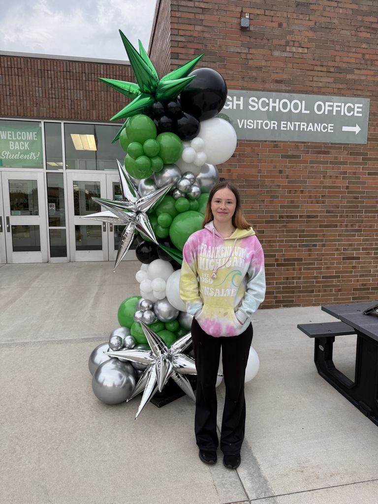 Students posing next to a ballon arch on the first day of school