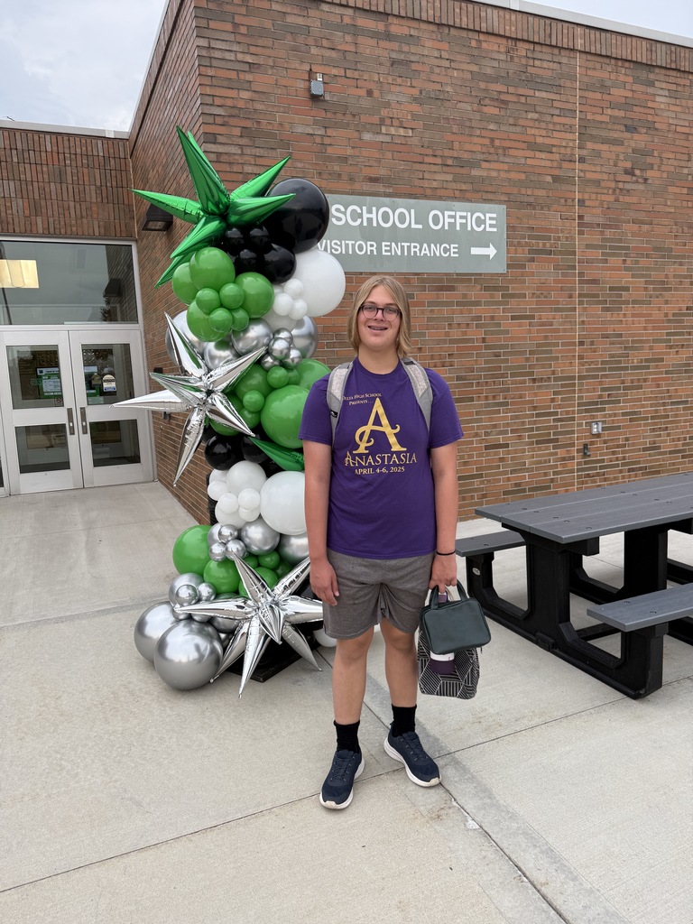 Students posing next to a ballon arch on the first day of school