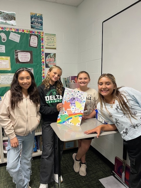 Students in a classroom painting a sign