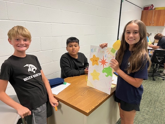 Students in a classroom painting a sign