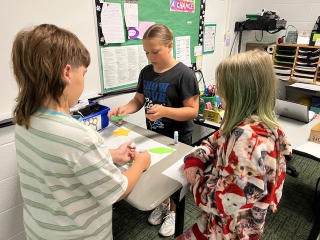 Students in a classroom painting a sign
