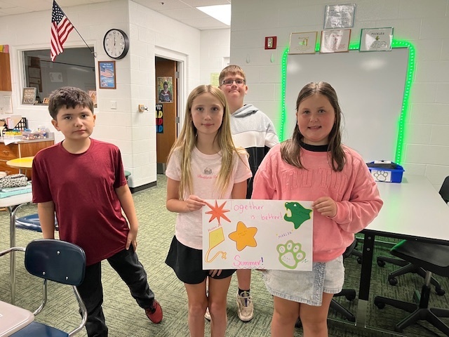 Students in a classroom painting a sign