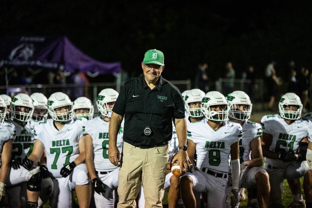 coach on the field by his players