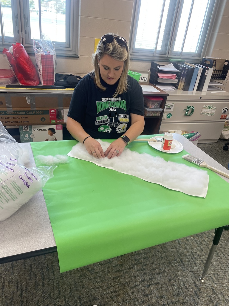 A teacher helping students with decorations for homecoming week