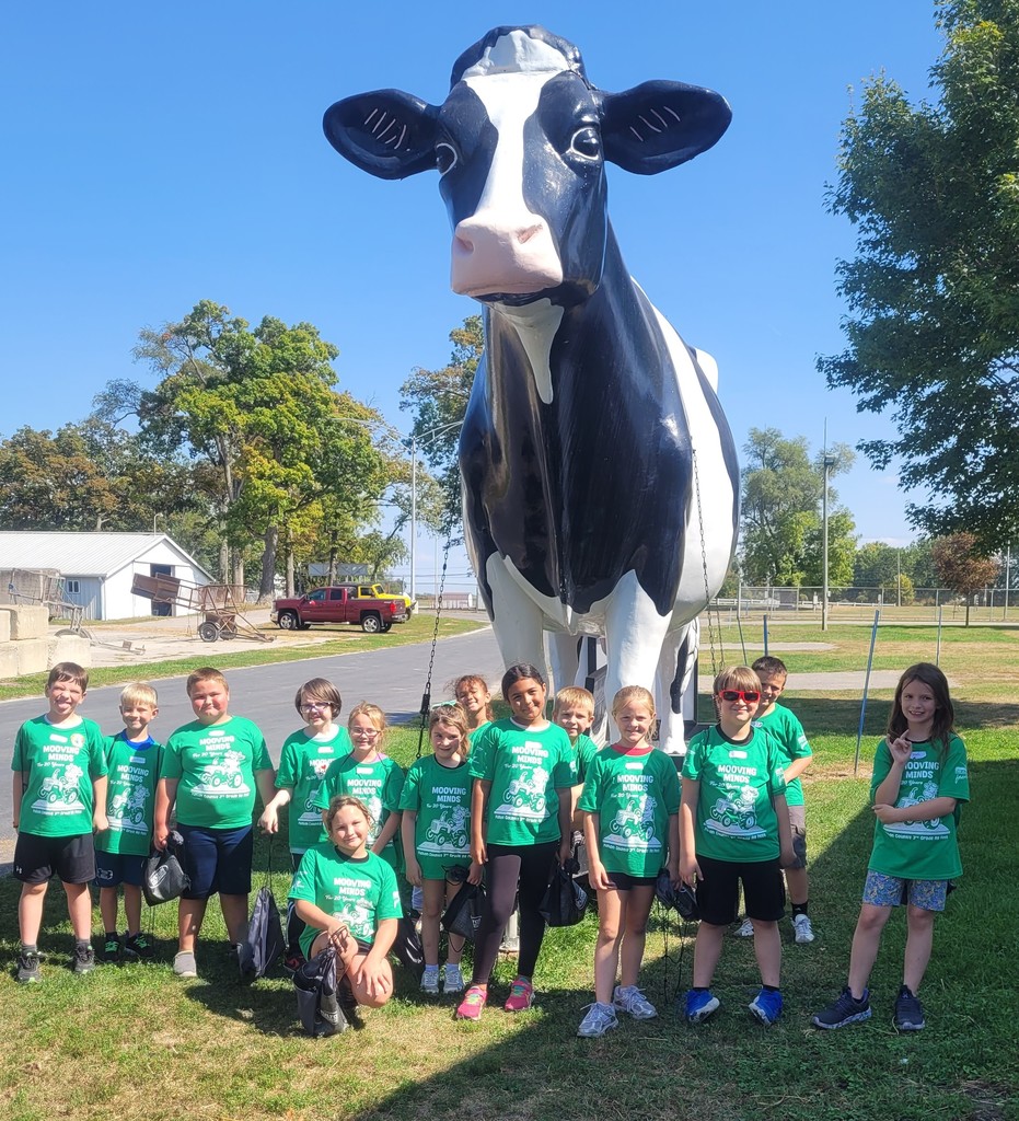 students posing by a statue