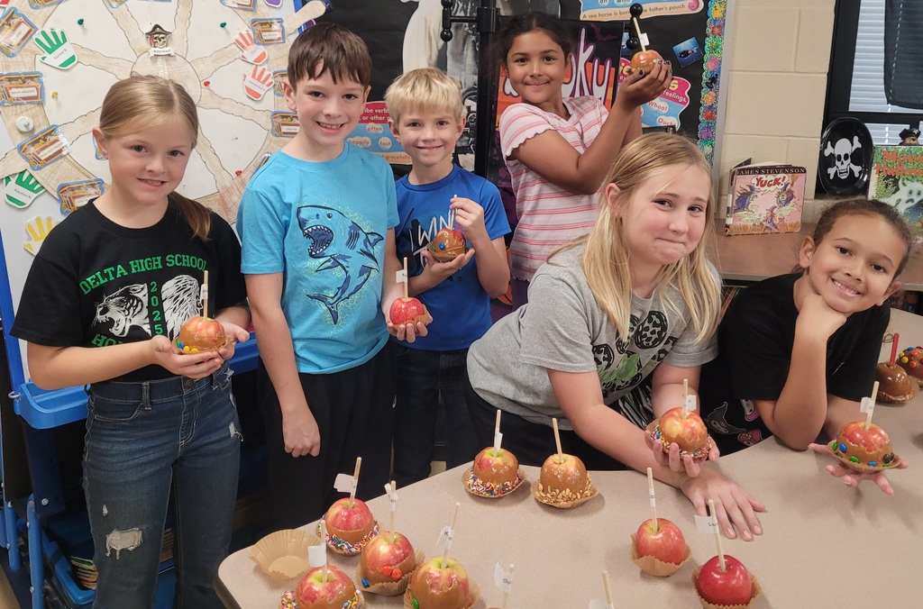 students posing near their caramel apples they made