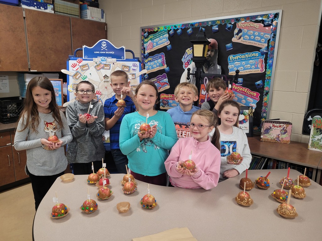 students posing near their caramel apples they made