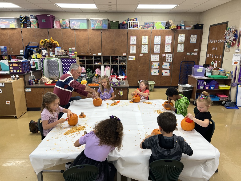 students carving pumpkins in a classroom