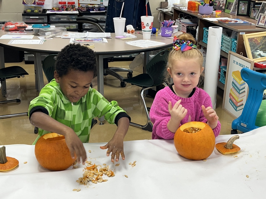 students carving pumpkins in a classroom