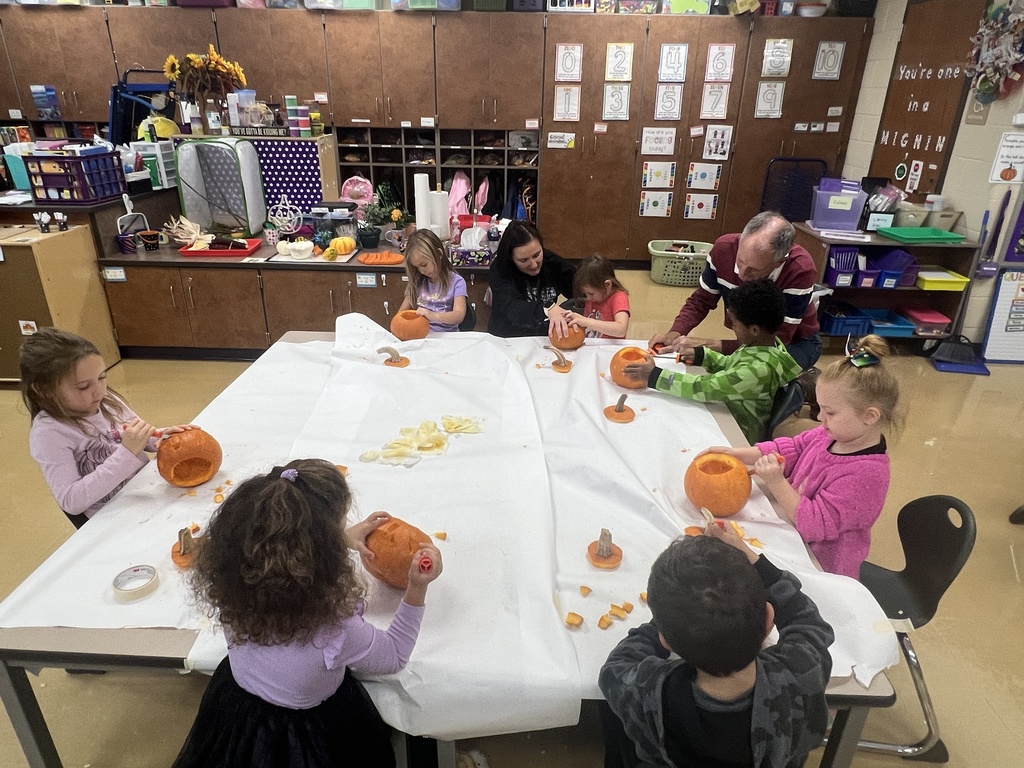 students carving pumpkins in a classroom