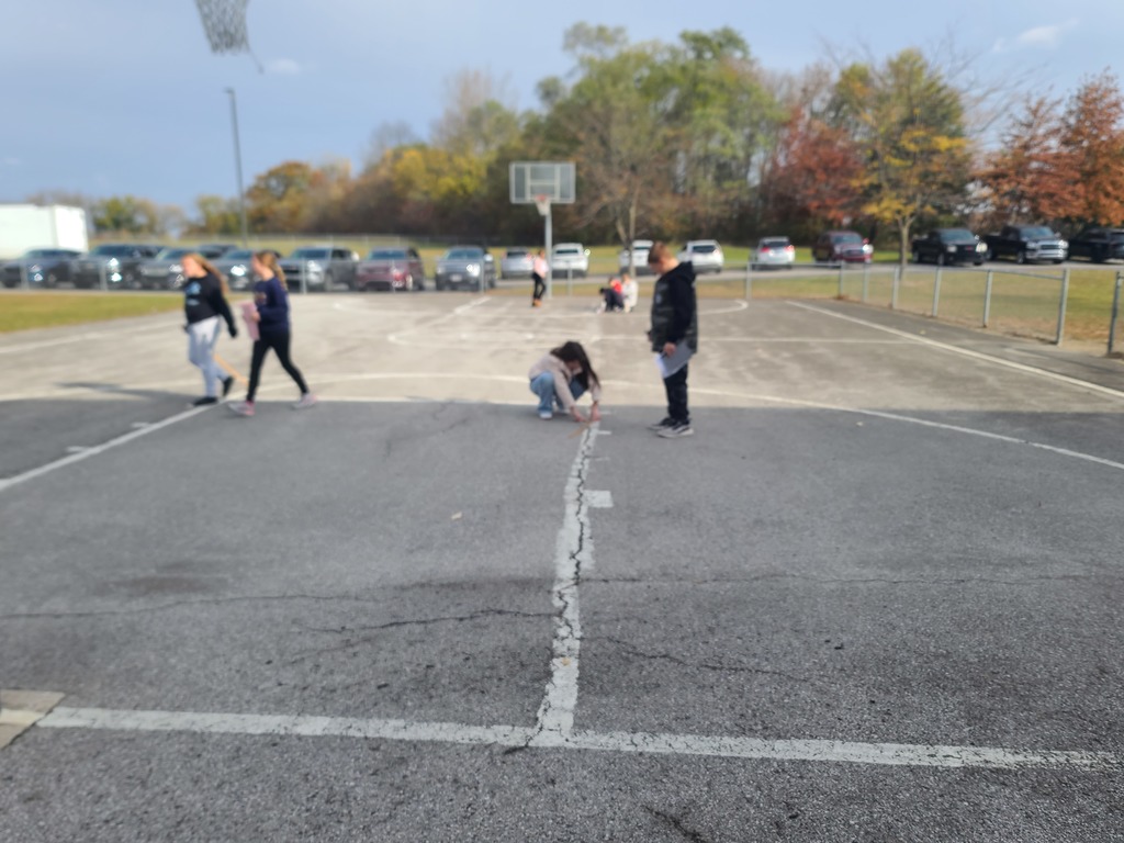 students measuring perimeter of outside objects