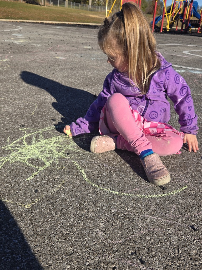 Student drawing with chalk outside