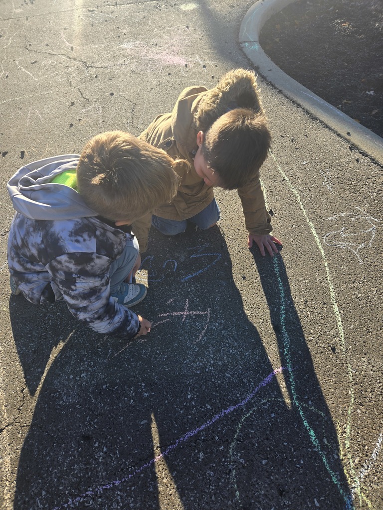Student drawing with chalk outside
