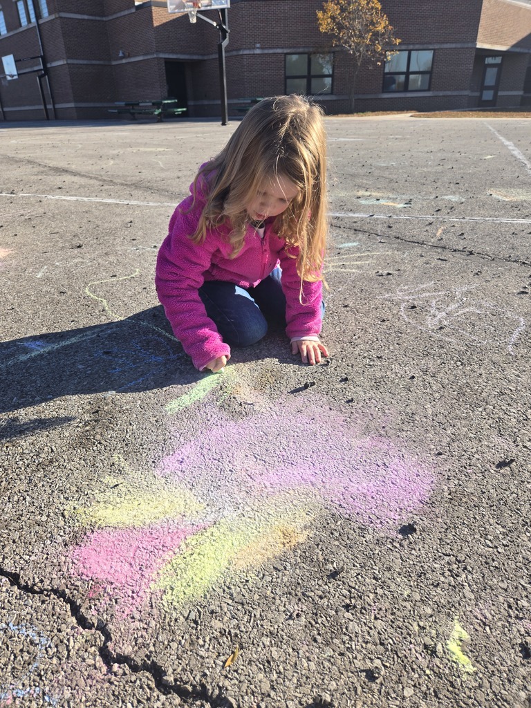 Student drawing with chalk outside