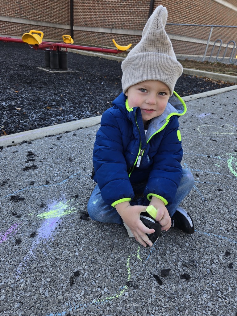 Student drawing with chalk outside