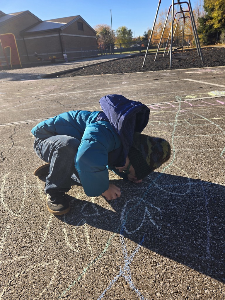 Student drawing with chalk outside