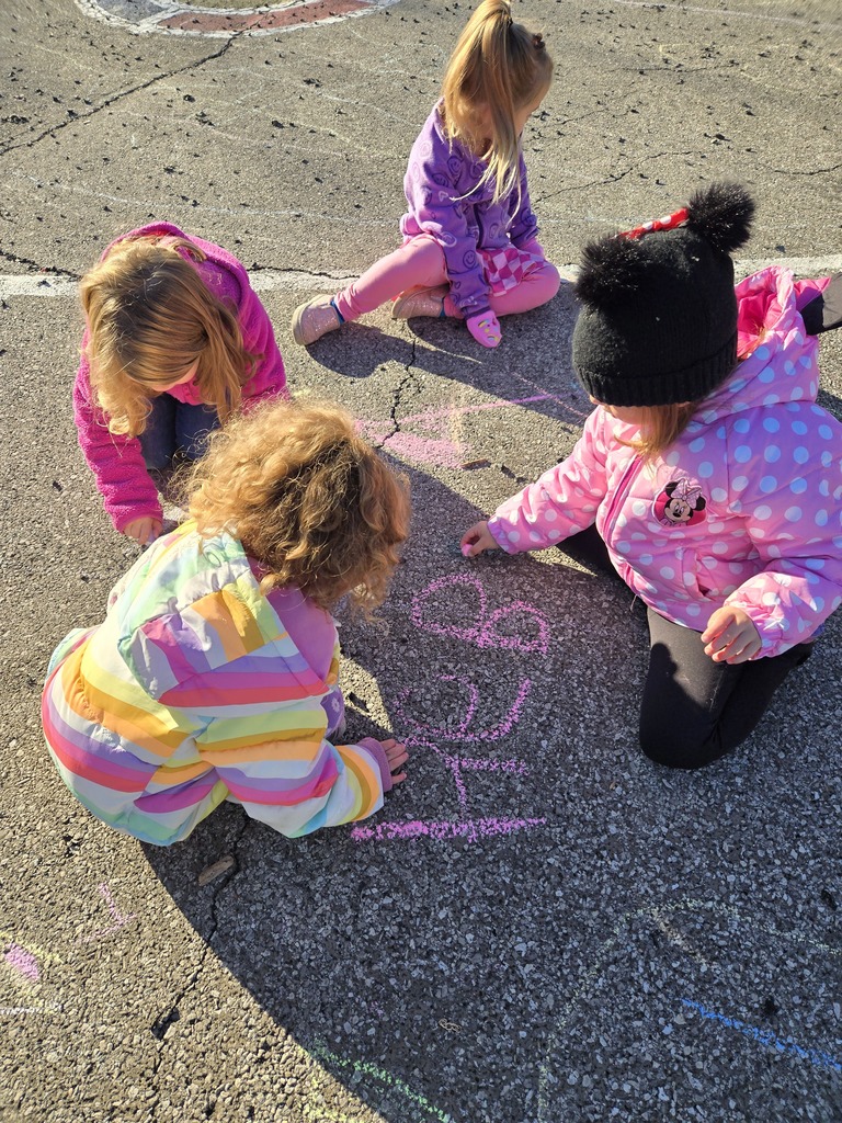 Student drawing with chalk outside