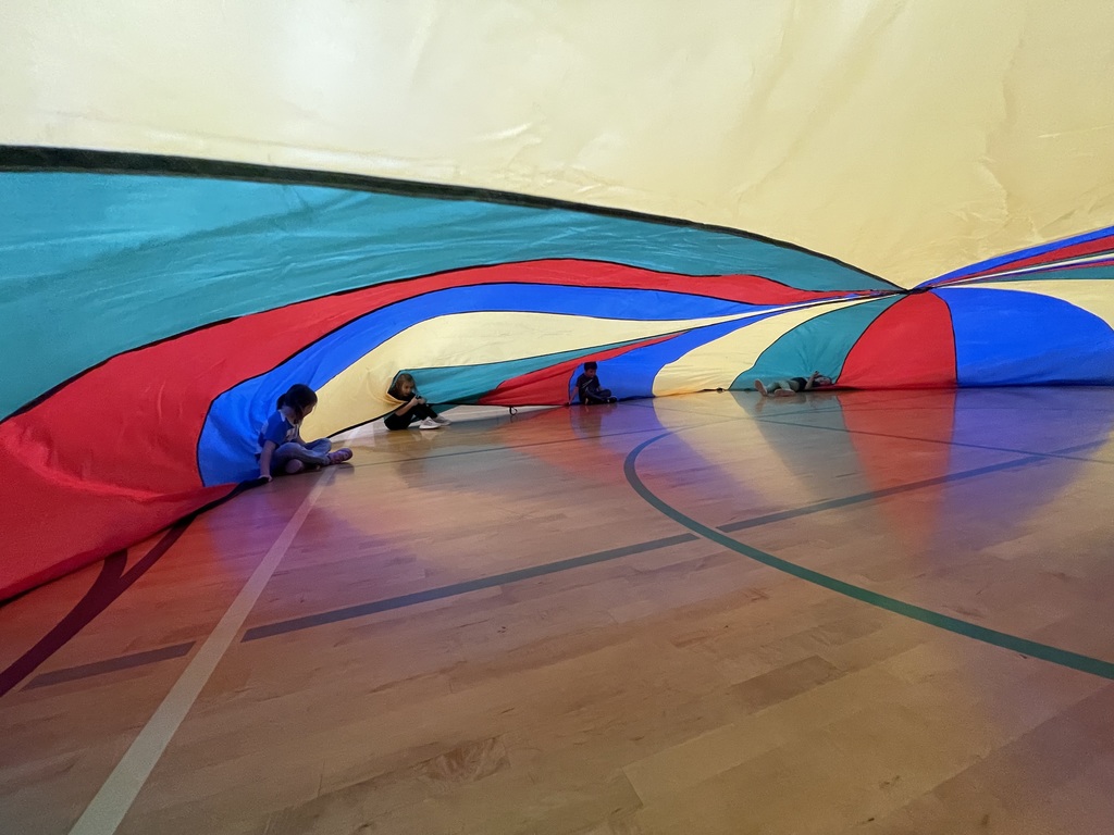 students playing with a parachute in PE class