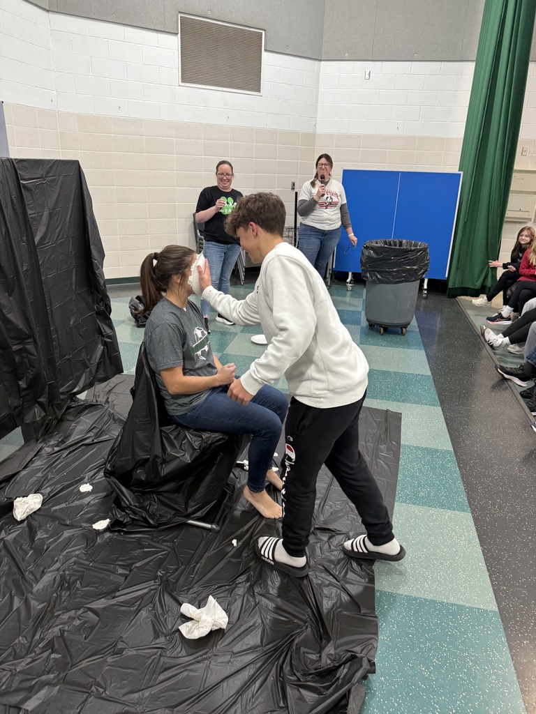 Students throwing pies in teacher's faces