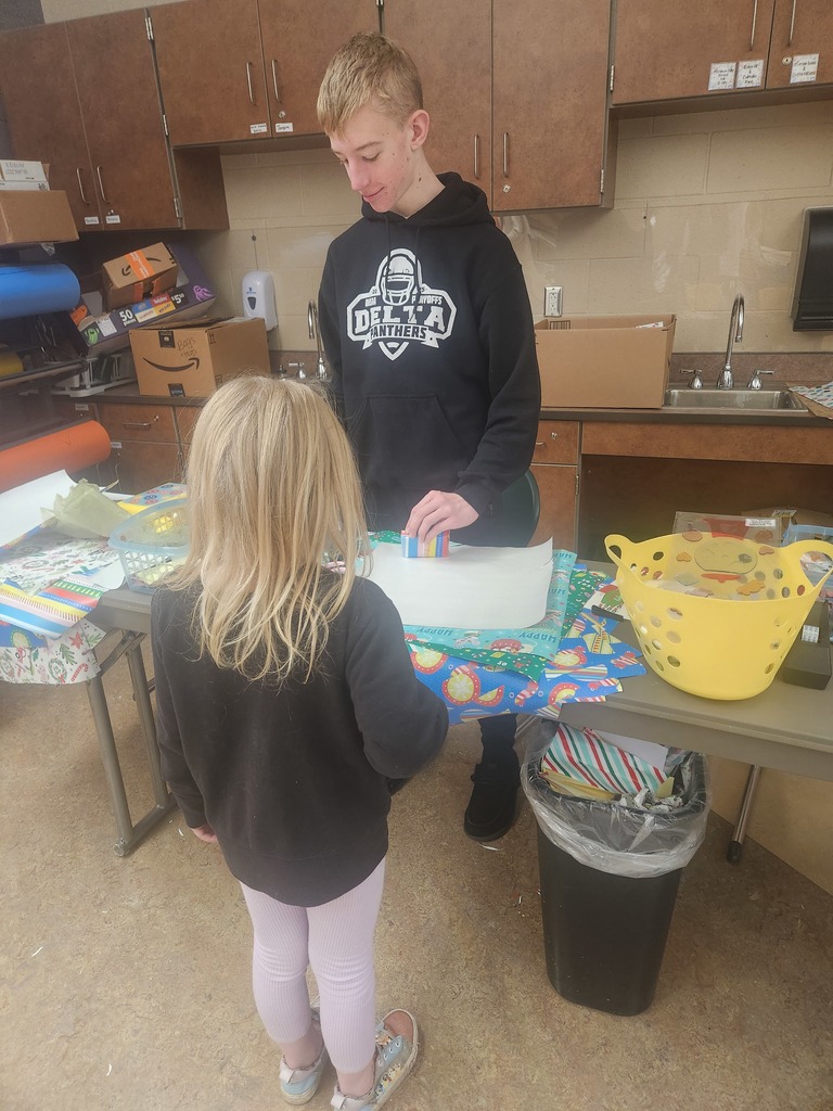 students helping out with a Santa shop at a school