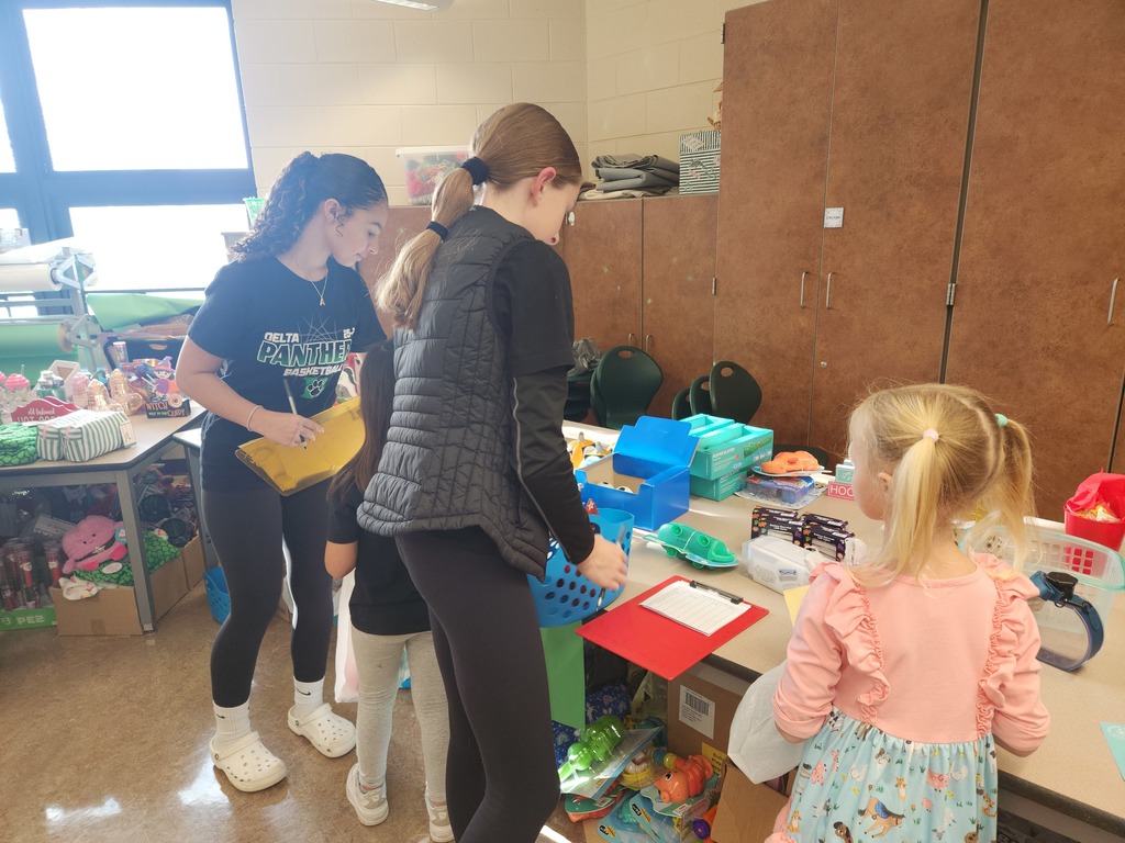 students helping out with a Santa shop at a school