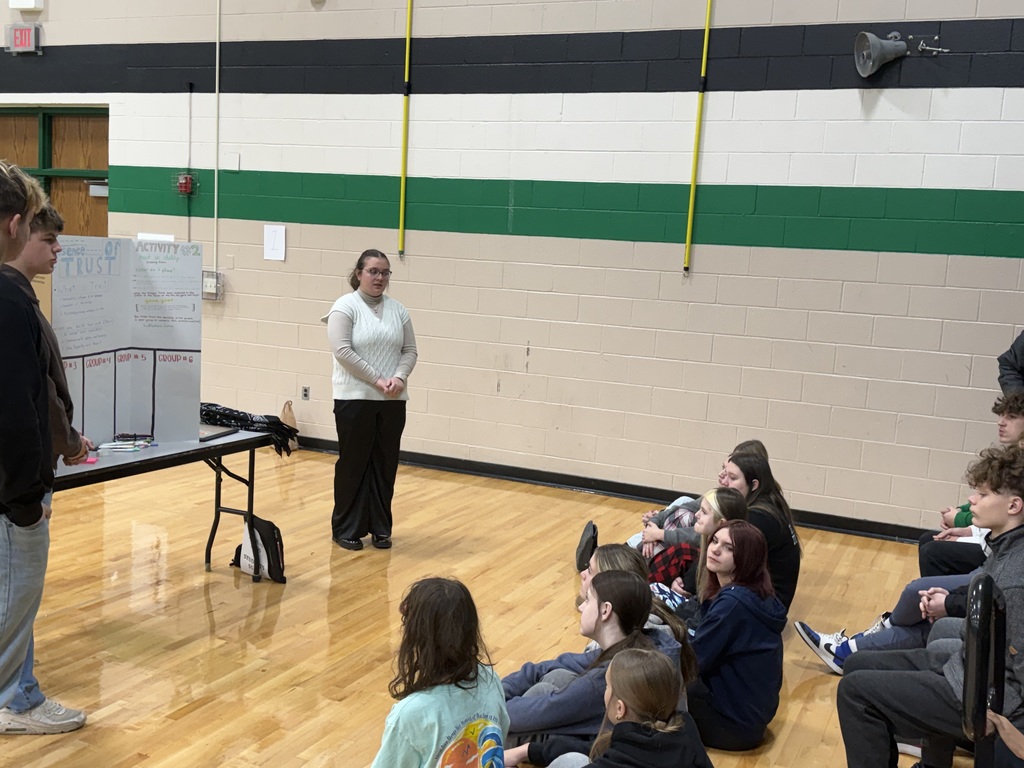 Students sitting on the floor in the gym